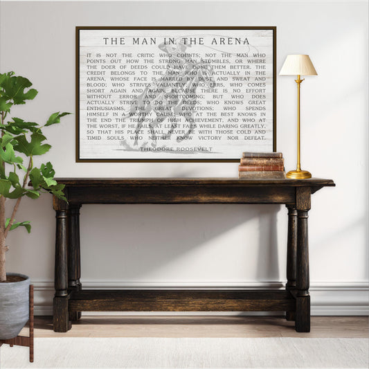 a wooden console table with a framed quote on the wall above it, and a lamp on the table.