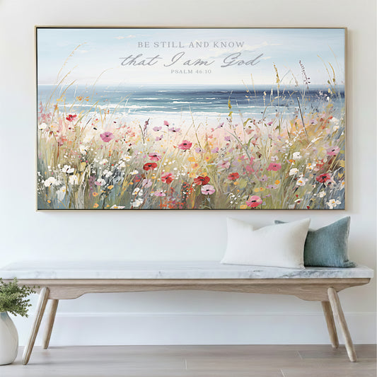 a large framed painting of a field of flowers hanging on a wall above a wooden bench.