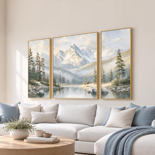 a cozy living room with a large, three-panel landscape painting of a mountain range hanging on the wall above a white sofa.