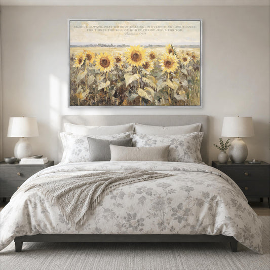 a large, framed painting of a field of sunflowers hanging above a bed with a floral comforter.