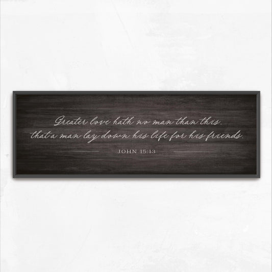 a black and white photograph of a wooden sign with a quote from the Bible verse John 15:13.