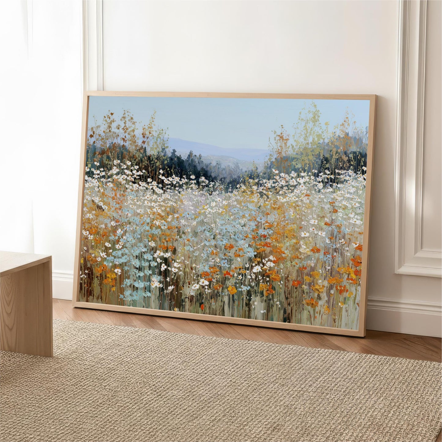 a large, framed painting of a field of flowers, with a variety of colors including white, orange, and green.