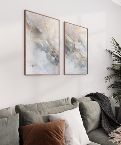a cozy living room with a gray couch adorned with brown and white pillows, and two framed abstract paintings hanging on the wall above the couch.