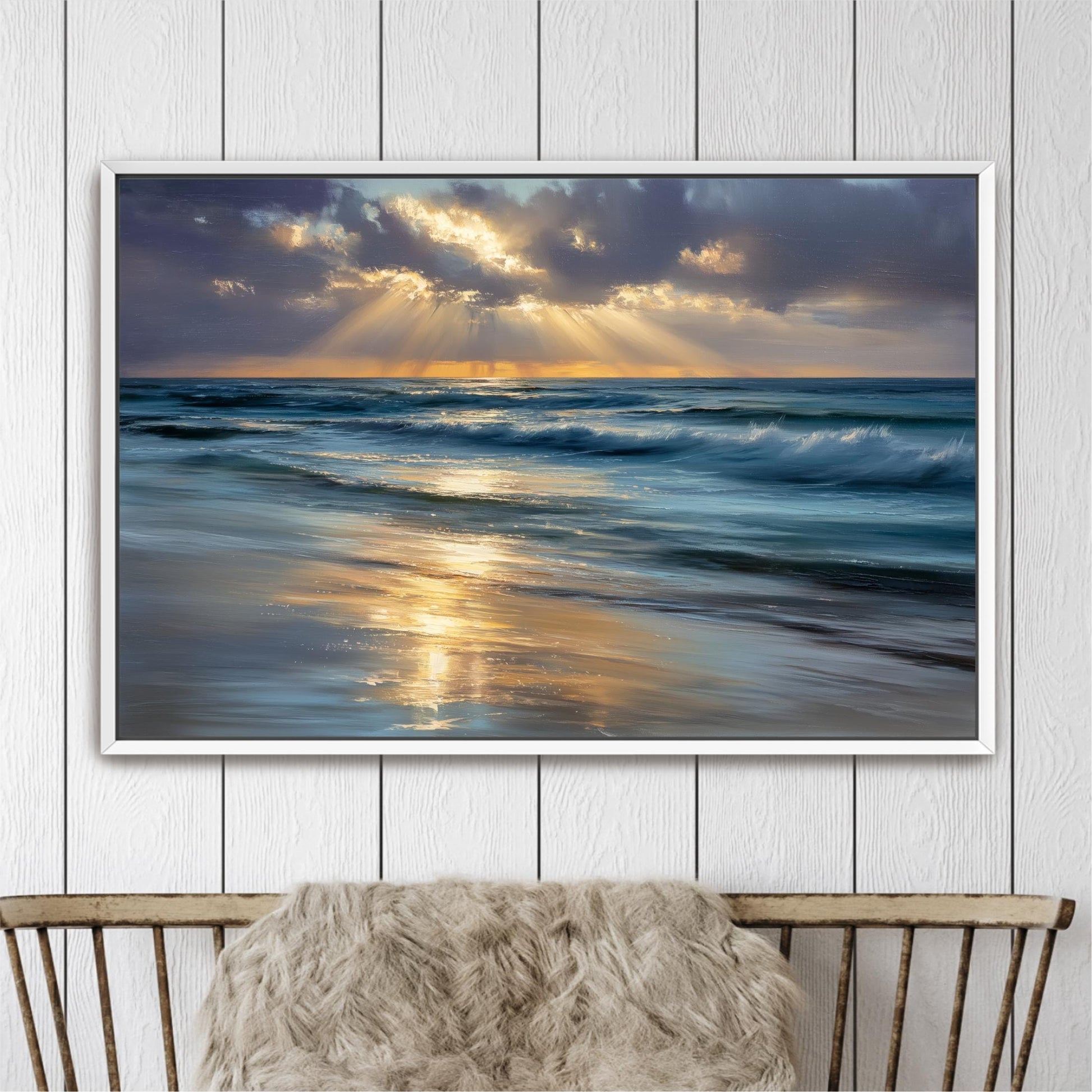 A framed painting depicting a serene beach scene with waves crashing against the shore, the sun setting in the distance, and the sky filled with clouds and sunbeams.