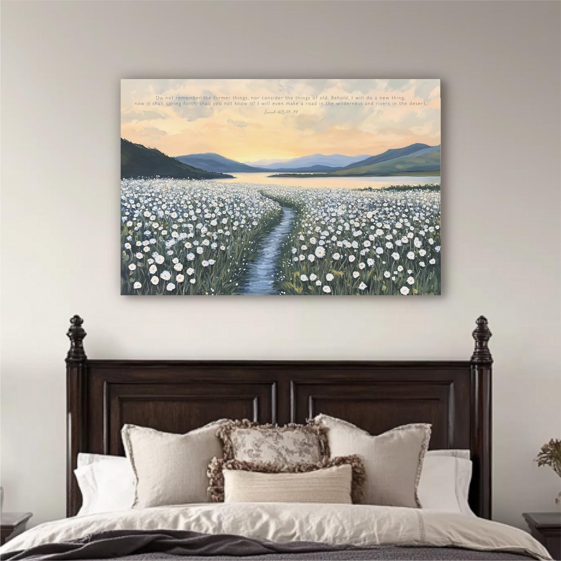 a serene bedroom scene with a large bed adorned with white pillows and a brown headboard. Above the bed, a large canvas print depicting a field of white flowers stretches across the wall, with a winding path leading through it. The sky above is a beautiful gradient of orange and blue, creating a peaceful and tranquil atmosphere.