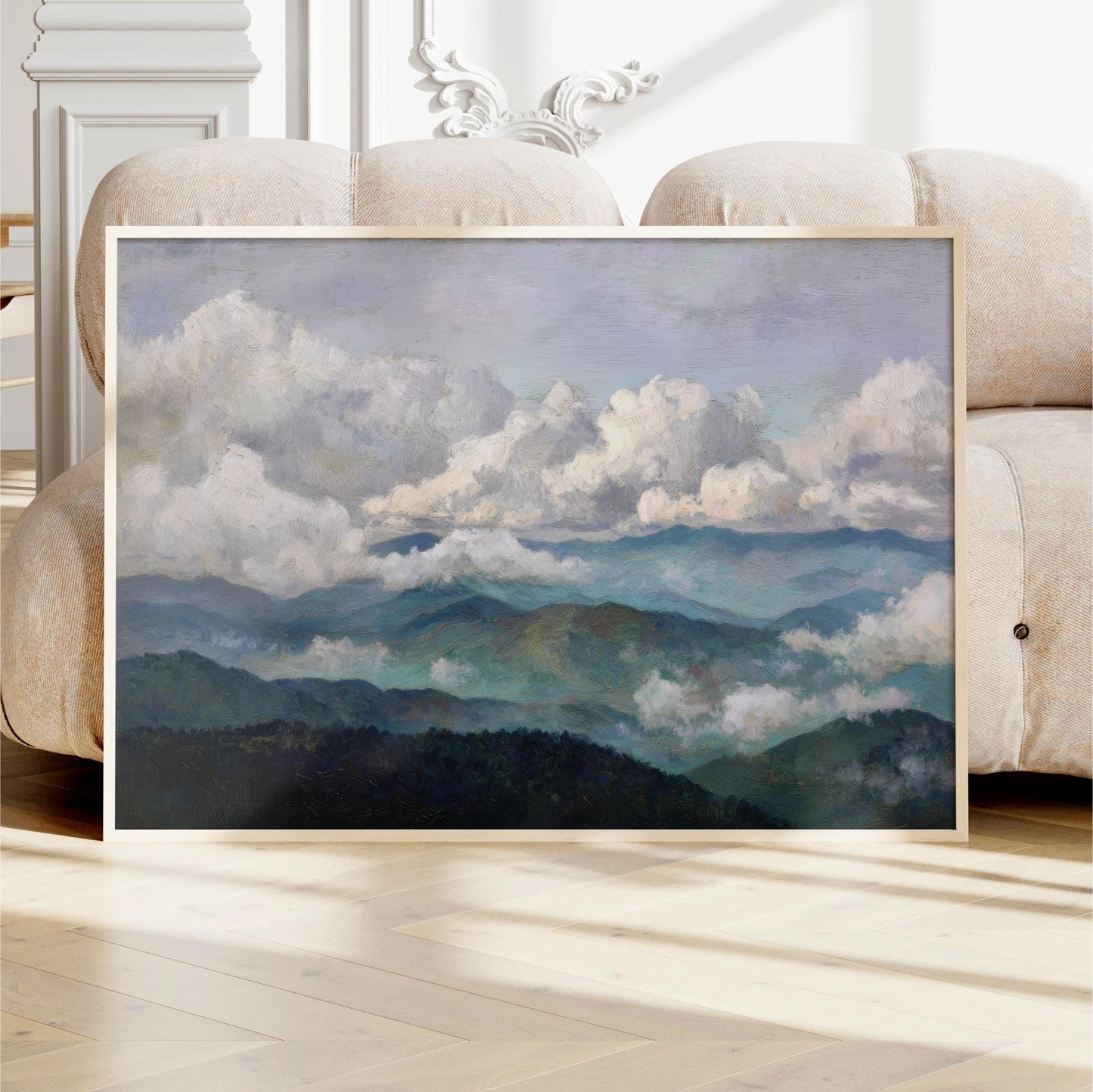 a large framed painting depicting a mountainous landscape with clouds in the sky.