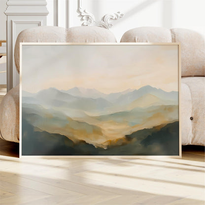 a large framed painting of a mountainous landscape, displayed on a wooden floor in front of a white couch.