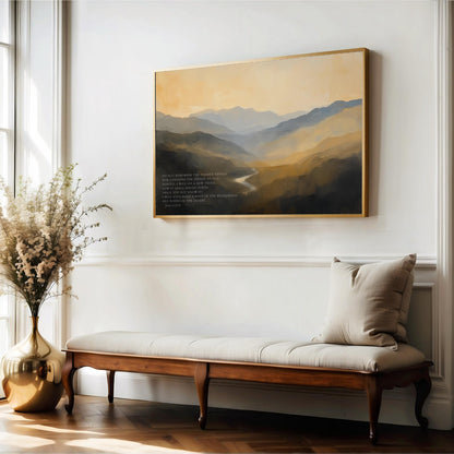 a serene indoor setting with a large painting of a mountainous landscape hanging on the wall above a wooden bench. The painting is framed in gold and depicts a tranquil scene of mountains and a winding river. The bench is positioned in front of the painting, creating a cozy and inviting atmosphere. A vase of flowers is also present in the room, adding a touch of natural beauty to the space.