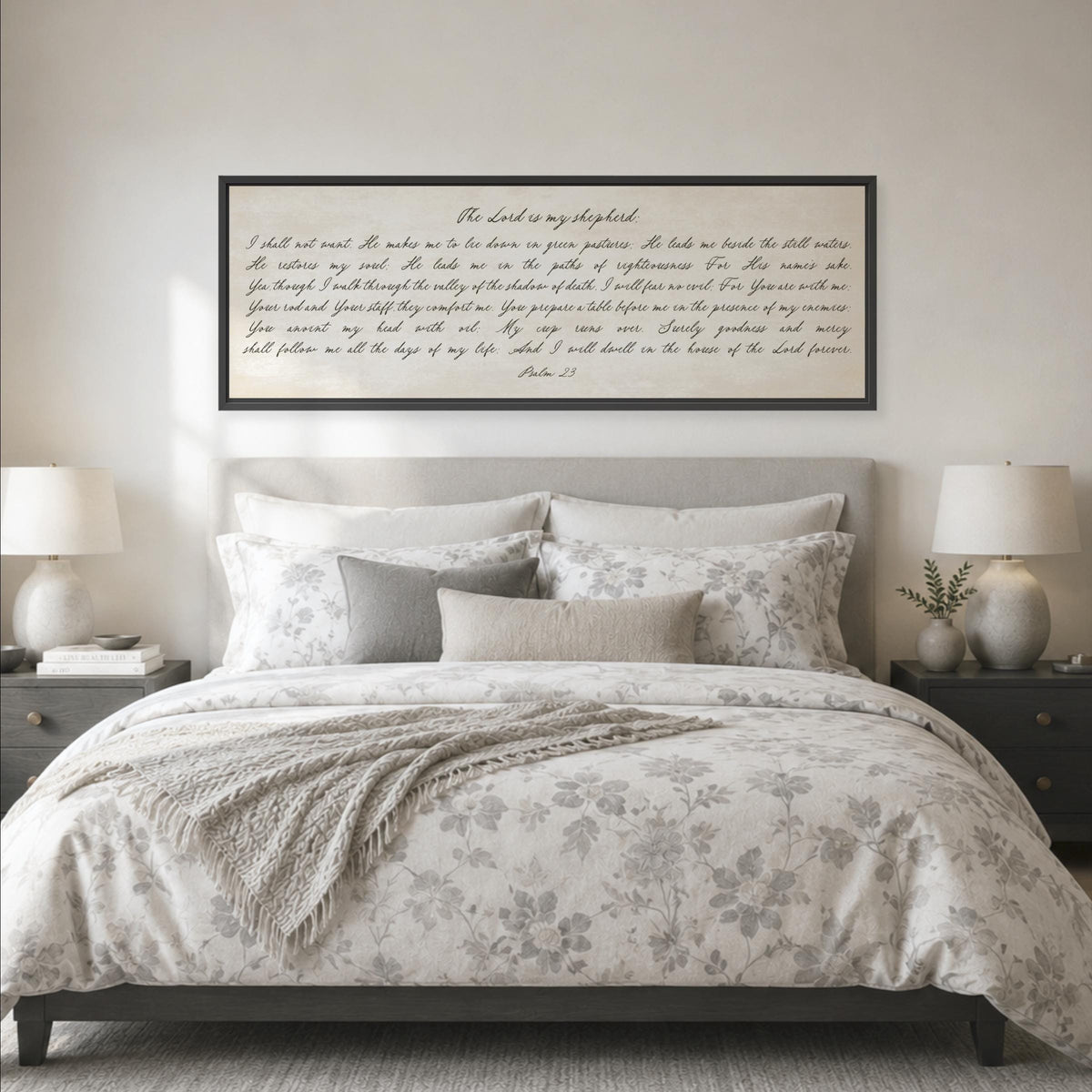 a bedroom with a large bed, a framed Bible verse, and two nightstands with lamps.
