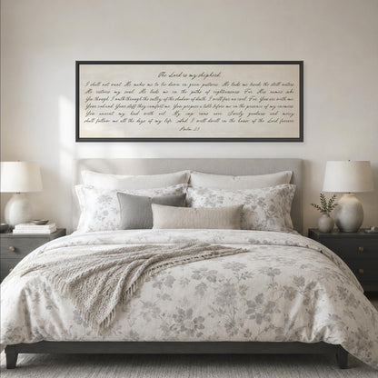 a bedroom with a large bed, a framed Bible verse, and two nightstands with lamps.