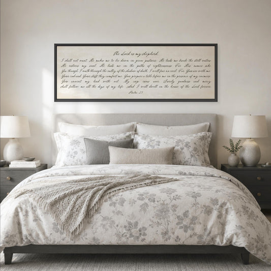a bedroom with a large bed, a framed Bible verse, and two nightstands with lamps.
