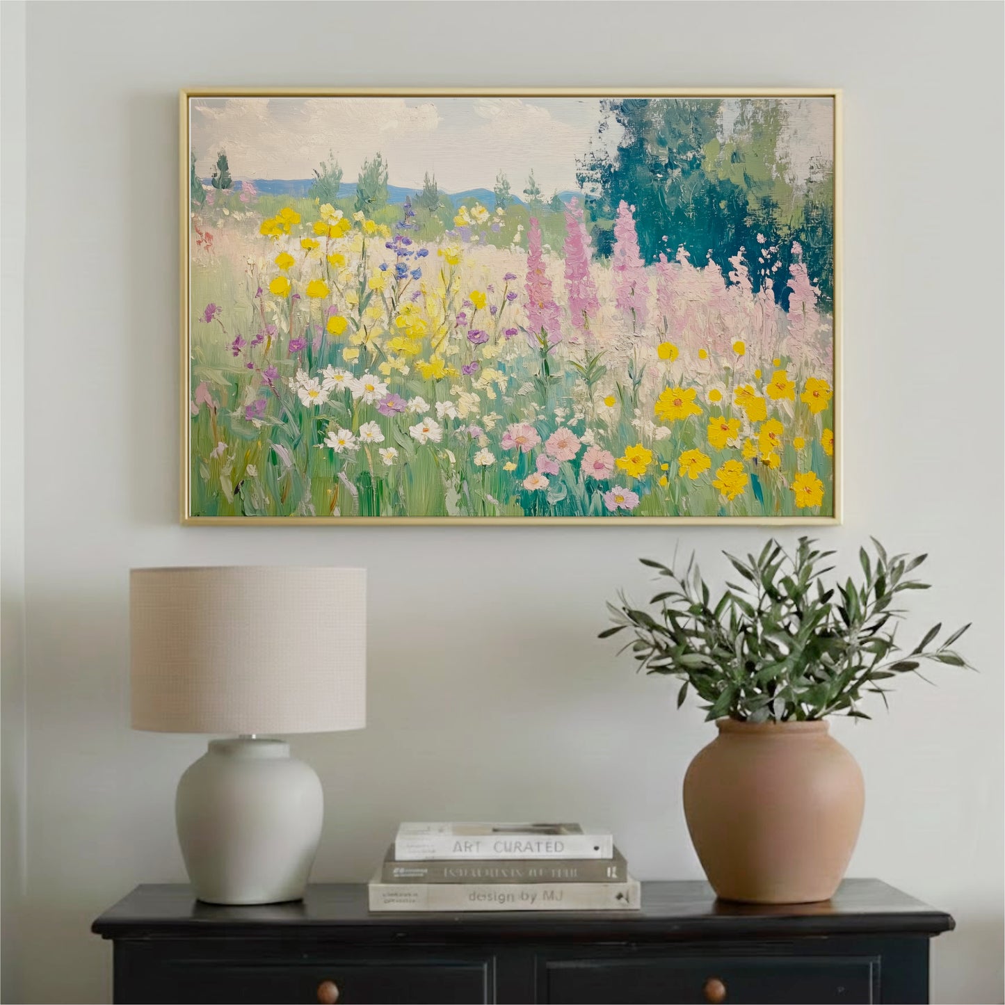 a painting of a colorful garden with flowers hanging on a wall above a wooden table with a lamp and a vase of greenery.