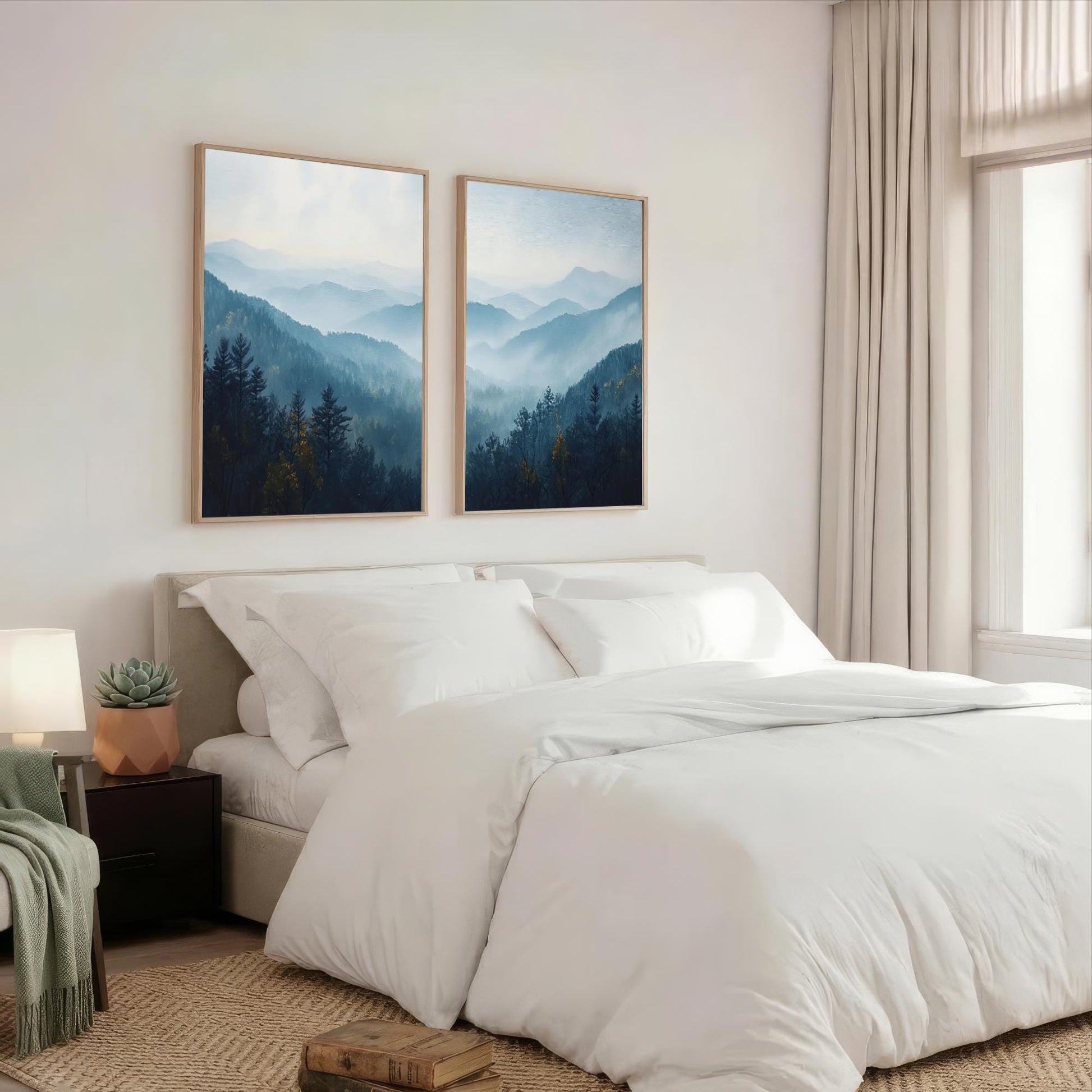a serene bedroom with a large bed, white bedding, and two framed landscape paintings hanging above it. The paintings feature a mountainous, forested scene with a blue sky and misty atmosphere.
