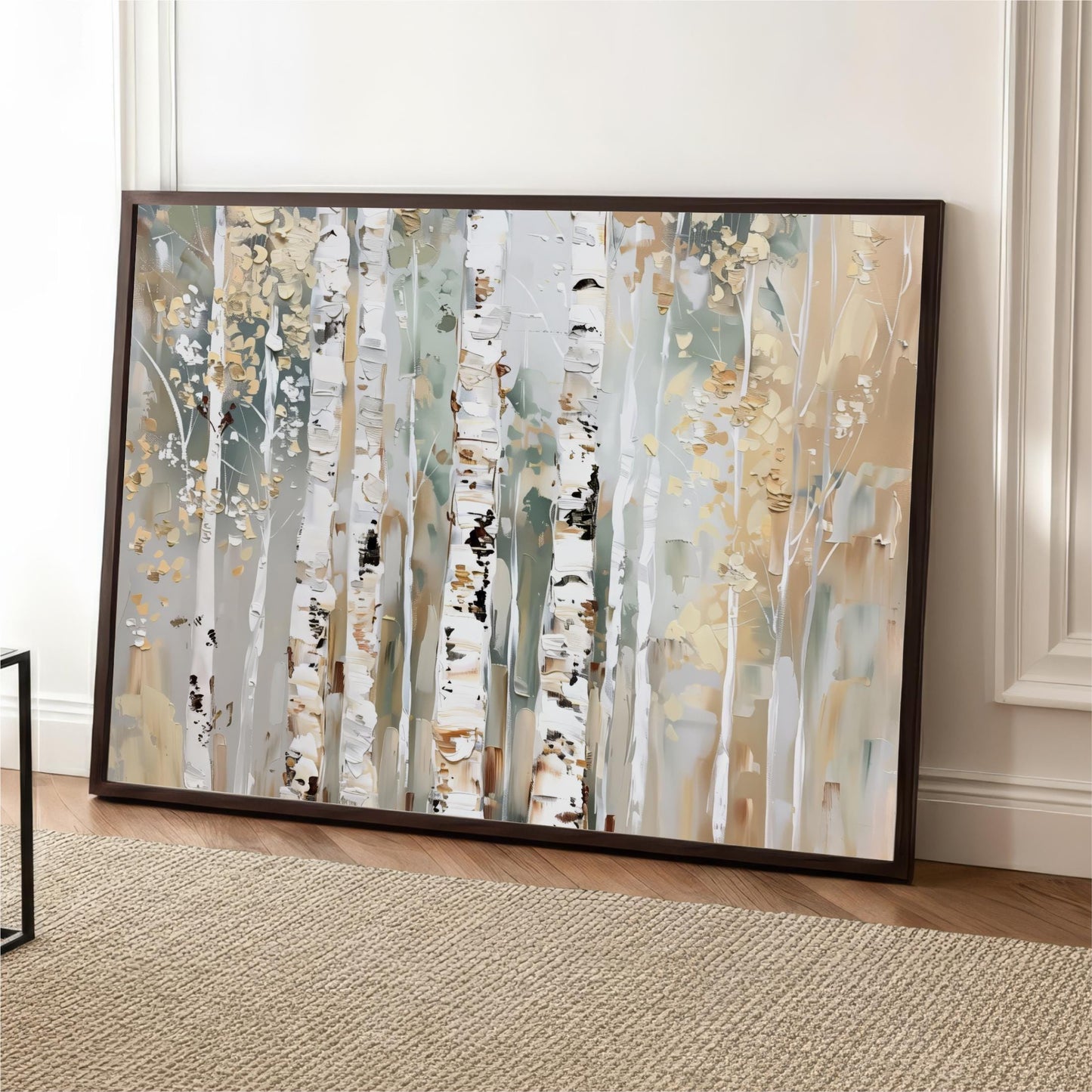 a large, framed painting of birch trees with a white bark and gold leaves, displayed on a wooden floor against a white wall.