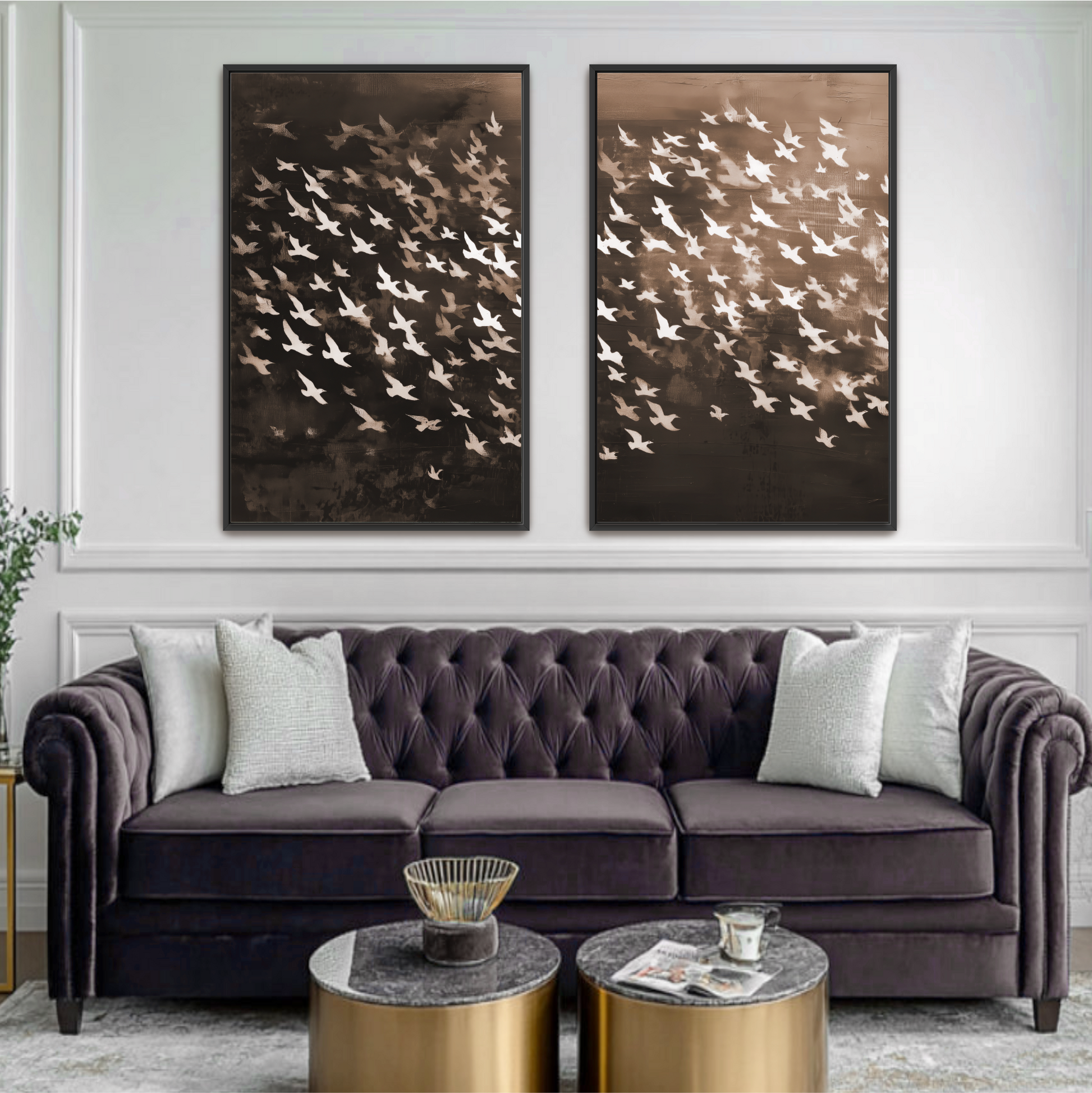 a living room with a large, tufted gray sofa adorned with white throw pillows. Above the sofa, there are two framed artworks depicting a flock of birds in flight. The room also includes a coffee table with a bowl and a cup on it, and a potted plant in the corner.