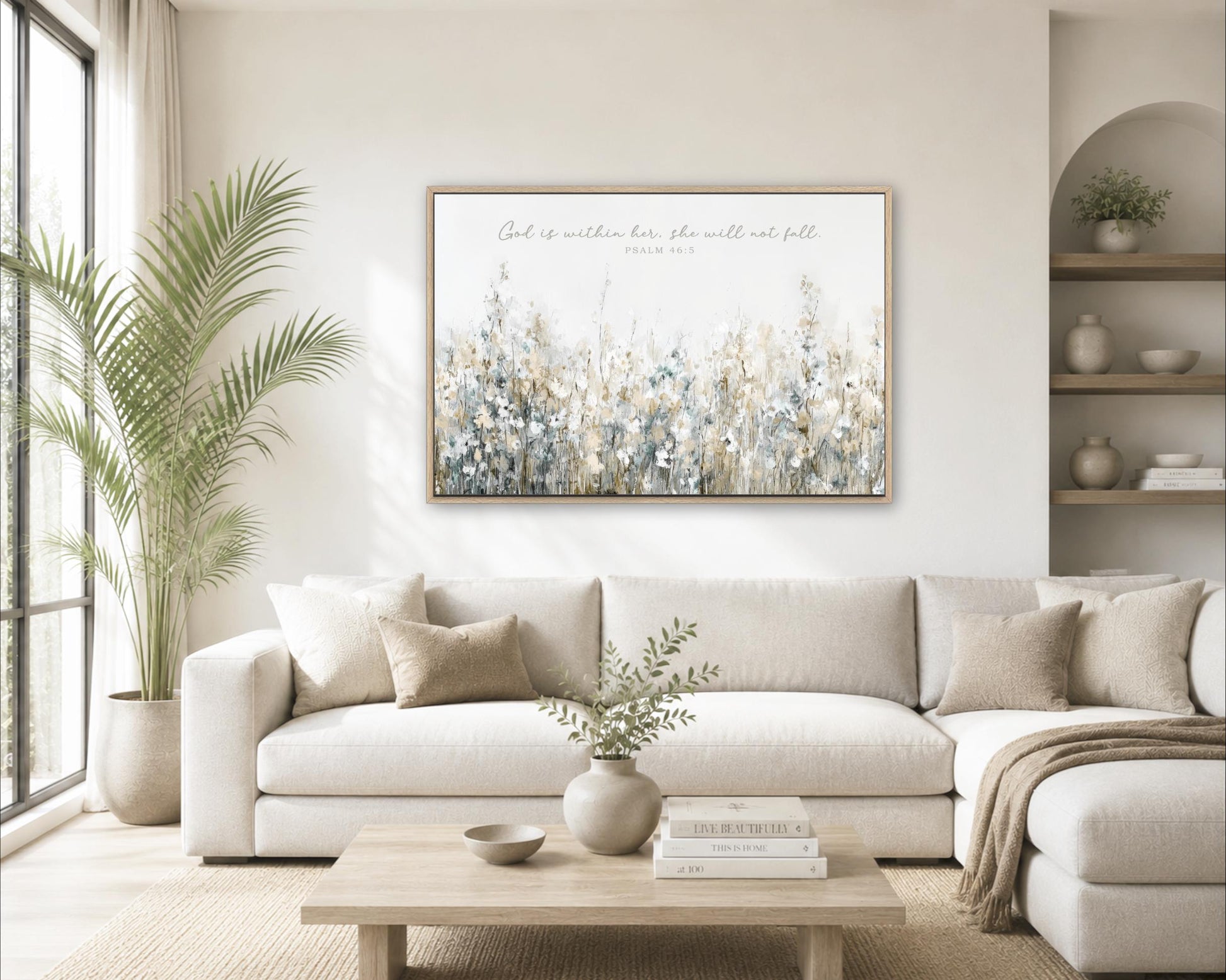 A living room with a large white sofa, a wooden coffee table, and a framed painting of a field of flowers hanging on the wall.