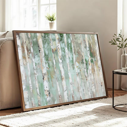 a large, framed painting of a forest scene with tall trees and a lush, green background. The painting is displayed on a wooden frame and is placed on a white rug in a living room setting.