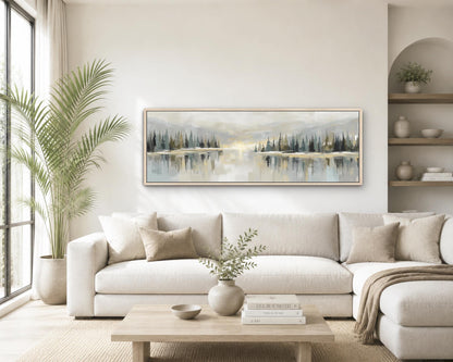 a serene living room with a large painting of a landscape featuring a lake and trees hanging on the wall above a white sofa. The room is decorated with a potted plant, a vase with greenery, and a stack of books on a coffee table.