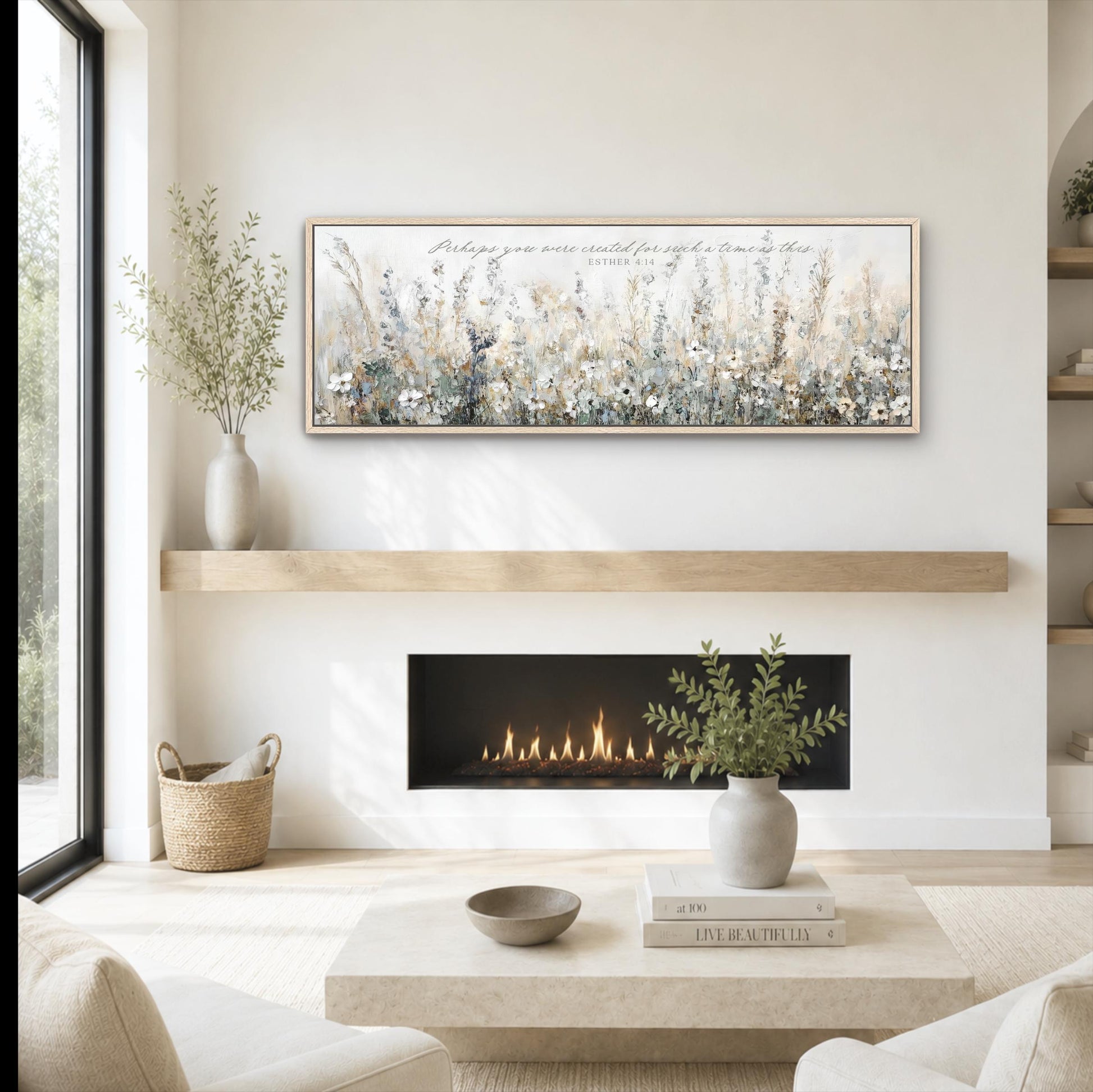a cozy living room with a fireplace, a coffee table, and a painting of a field of flowers hanging above it. The room has a minimalist and modern design, with a large window providing natural light and a view of the outdoors.
