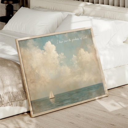 A framed painting of a sailboat on the ocean is displayed on a bed, with a white pillow and blanket nearby.
