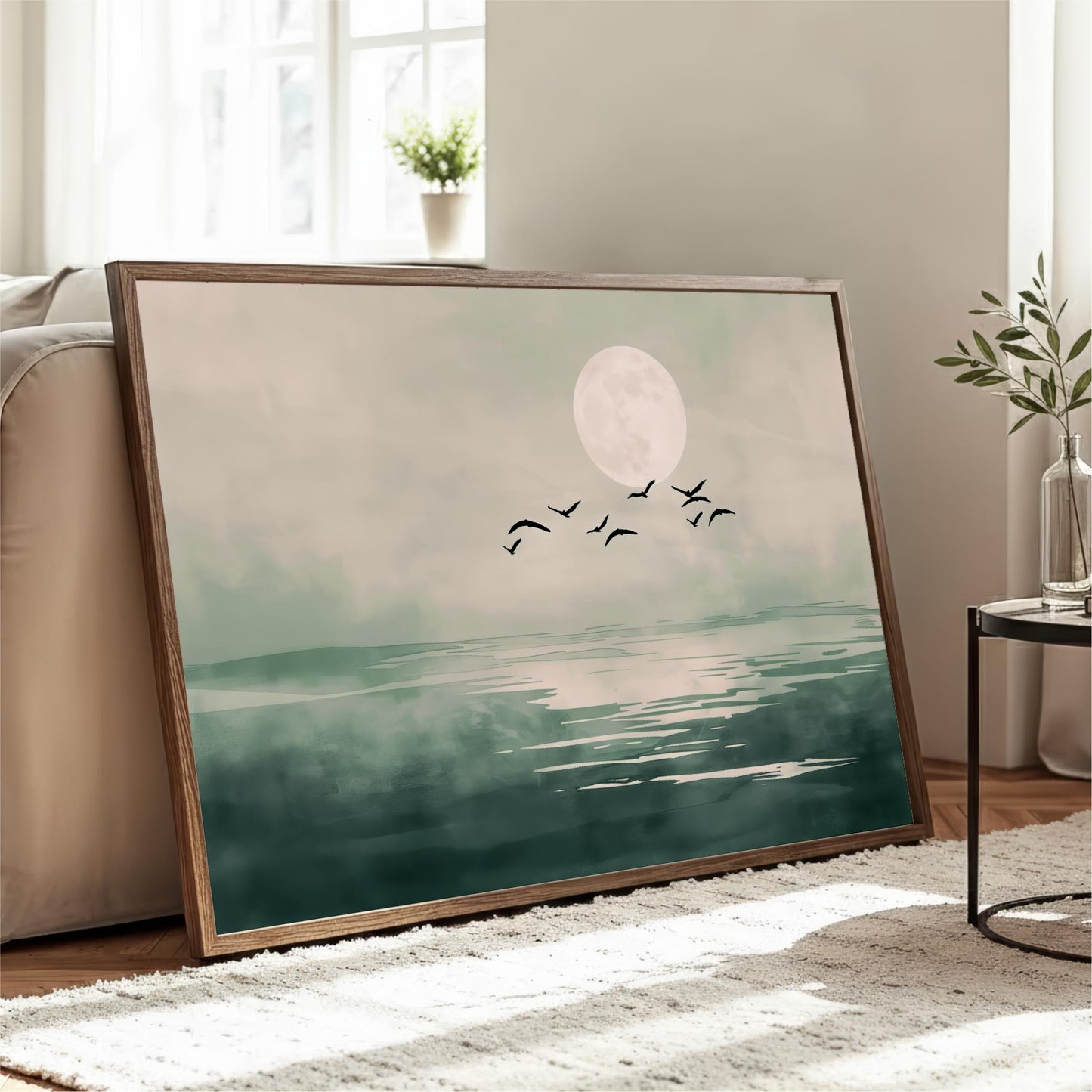 a large framed painting depicting a serene landscape with a full moon, birds flying over a body of water, and a cozy indoor setting with a couch and a potted plant.