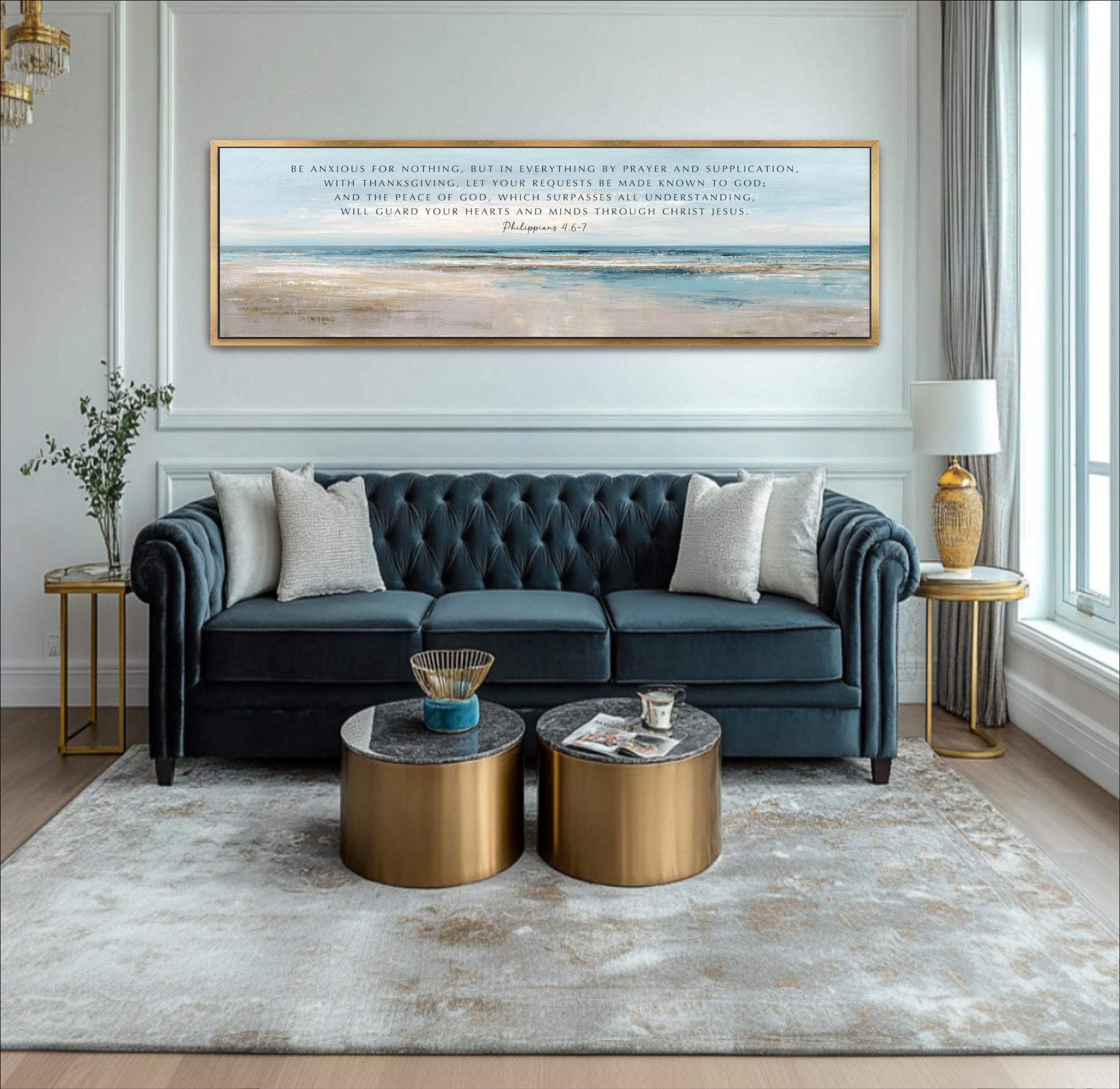 A living room with a blue tufted sofa, two round coffee tables, and a large framed painting on the wall. The painting depicts a beach scene with a blue sky and ocean.
