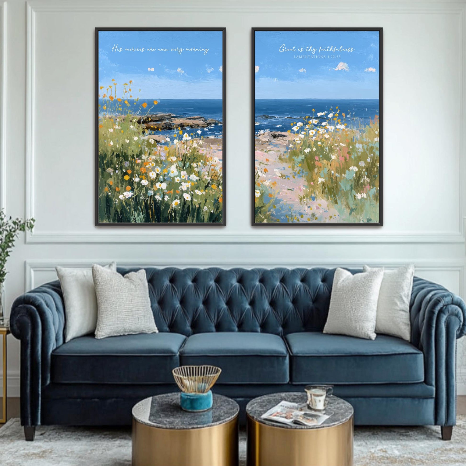 a living room with a blue tufted sofa, two framed paintings of a coastal landscape, and a coffee table in front of the sofa.