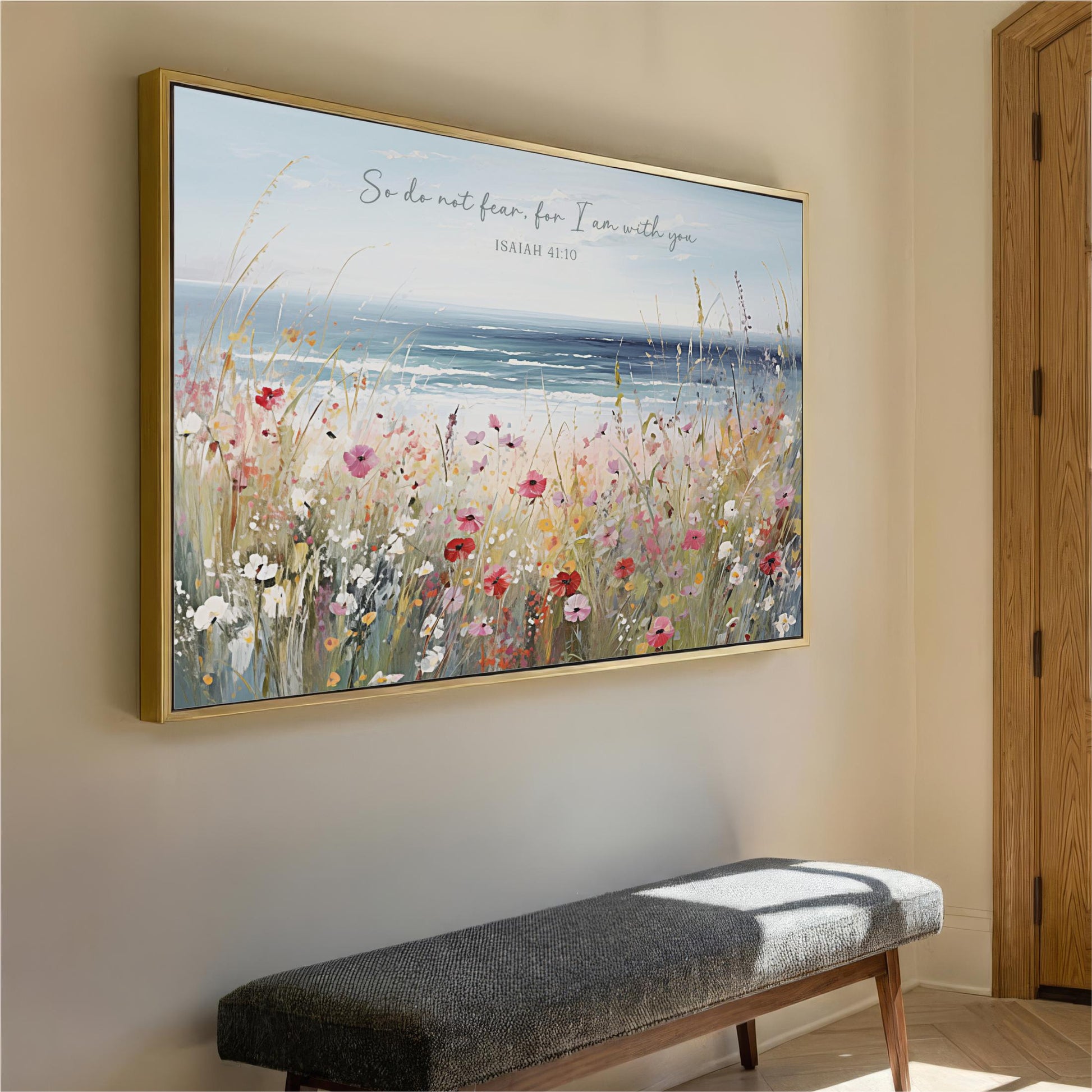 a large framed painting of a field of flowers hanging on a wall, with a bench below it.