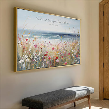 a large framed painting of a field of flowers hanging on a wall, with a bench below it.