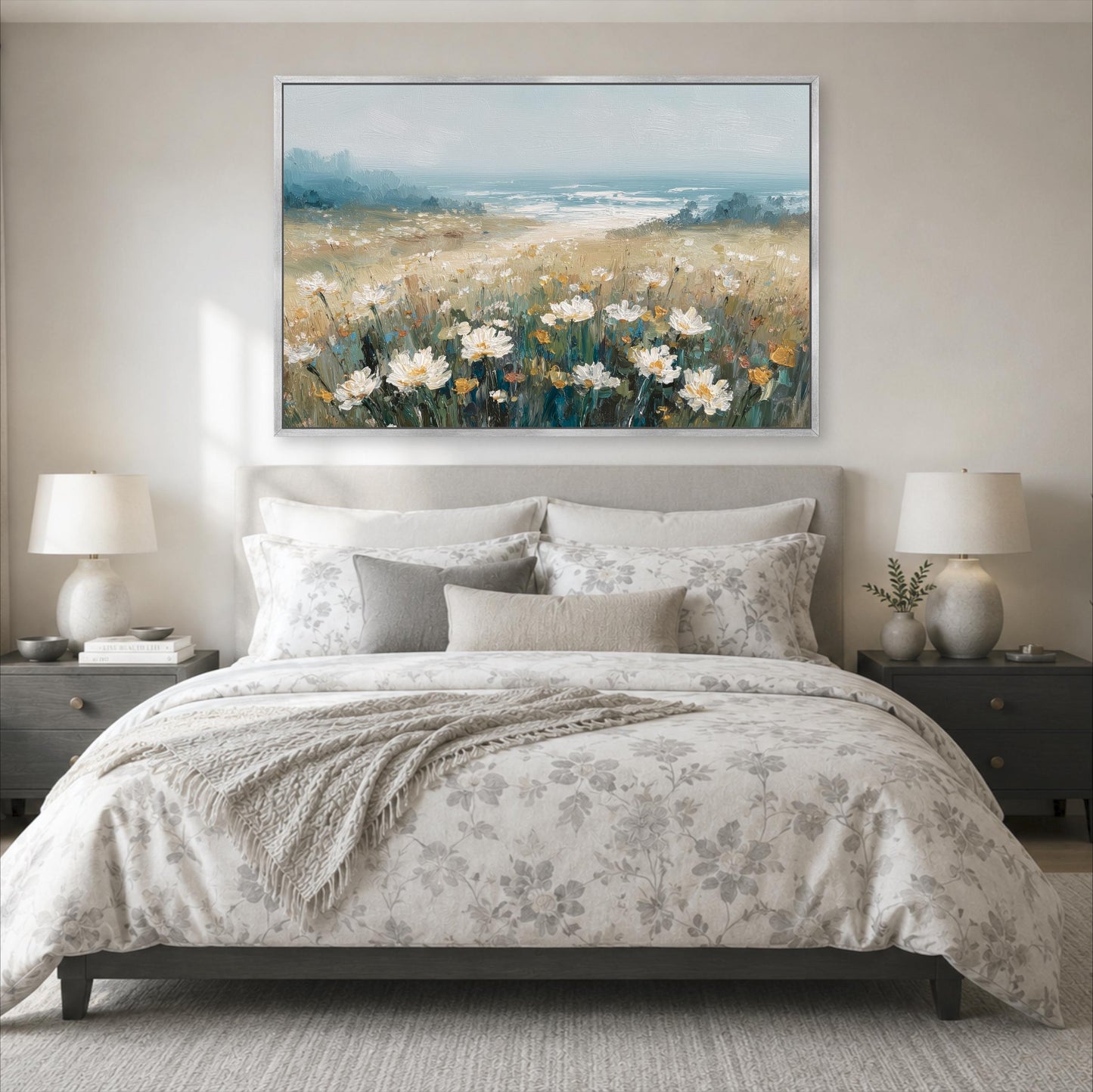 a serene bedroom scene with a large bed adorned with a floral comforter and pillows, flanked by two nightstands with lamps. Above the bed, a large painting of a field of flowers is displayed on the wall, creating a peaceful and inviting atmosphere.