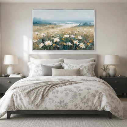 a serene bedroom scene with a large bed adorned with a floral comforter and pillows, flanked by two nightstands with lamps. Above the bed, a large painting of a field of flowers is displayed on the wall, creating a peaceful and inviting atmosphere.
