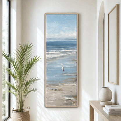 a large painting of a seagull standing on a beach, with the ocean in the background. The painting is hung on a wall, and there is a potted plant and a vase on a table nearby.