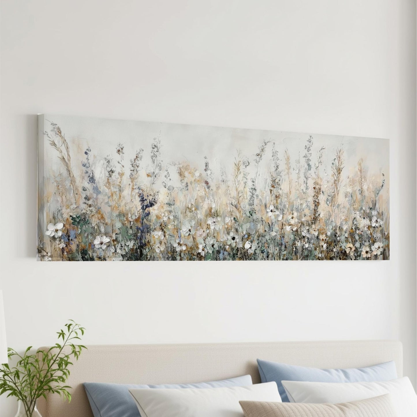 a large, long painting of a field of flowers hanging on a wall above a bed with pillows.
