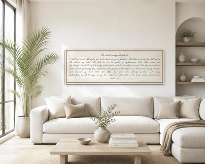 a living room with a large white sofa, a wooden coffee table, and a framed Bible verse displayed on the wall.
