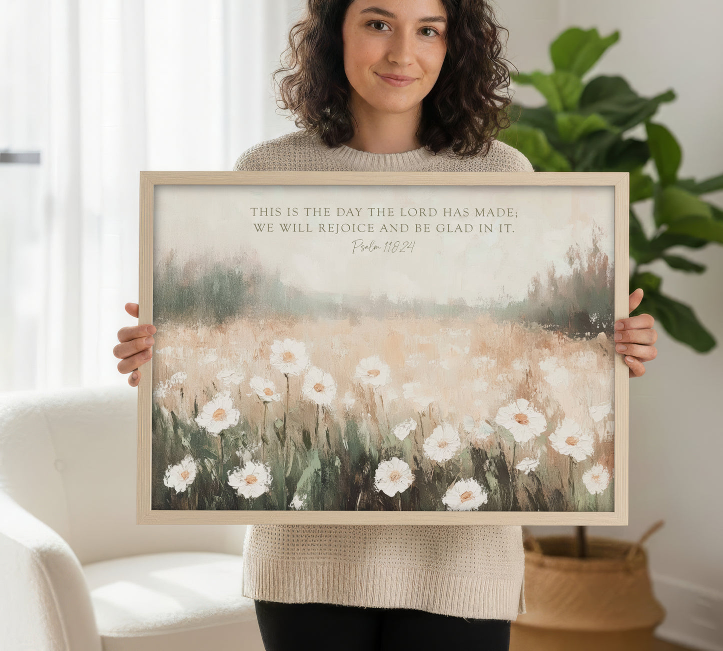 A woman is holding a framed print of a painting of a field of white flowers.