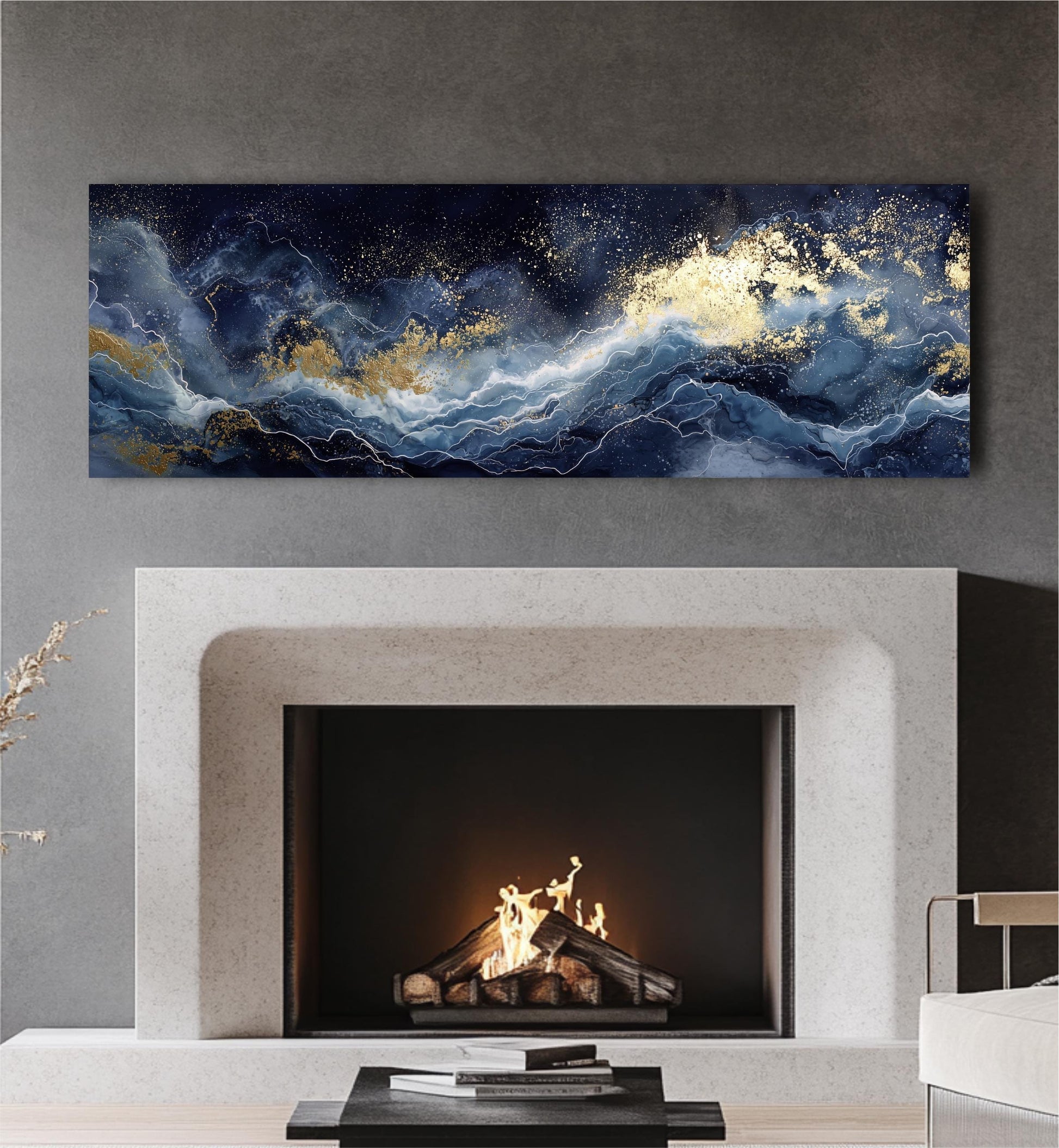 a fireplace with a fire burning inside, and a large abstract painting above it. The painting has a dark blue and white color scheme with gold accents, creating a striking contrast against the dark background. The fireplace is situated in a modern living room setting, with a white sofa and a coffee table visible in the background.
