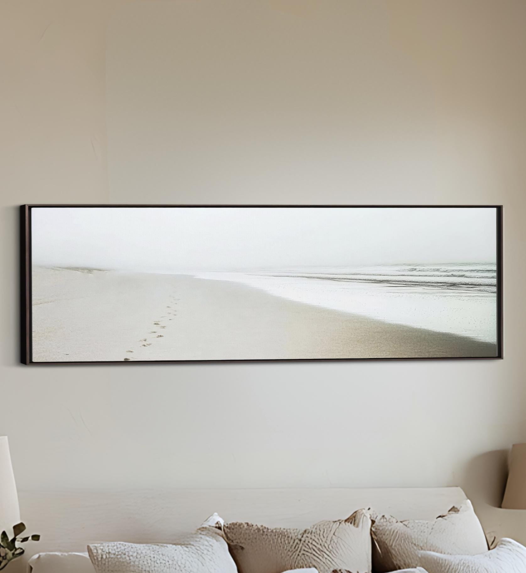 a bed with a white comforter and a picture on the wall