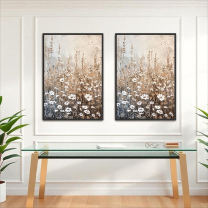 two framed paintings of flowers hanging on a white wall above a glass table with a white surface.