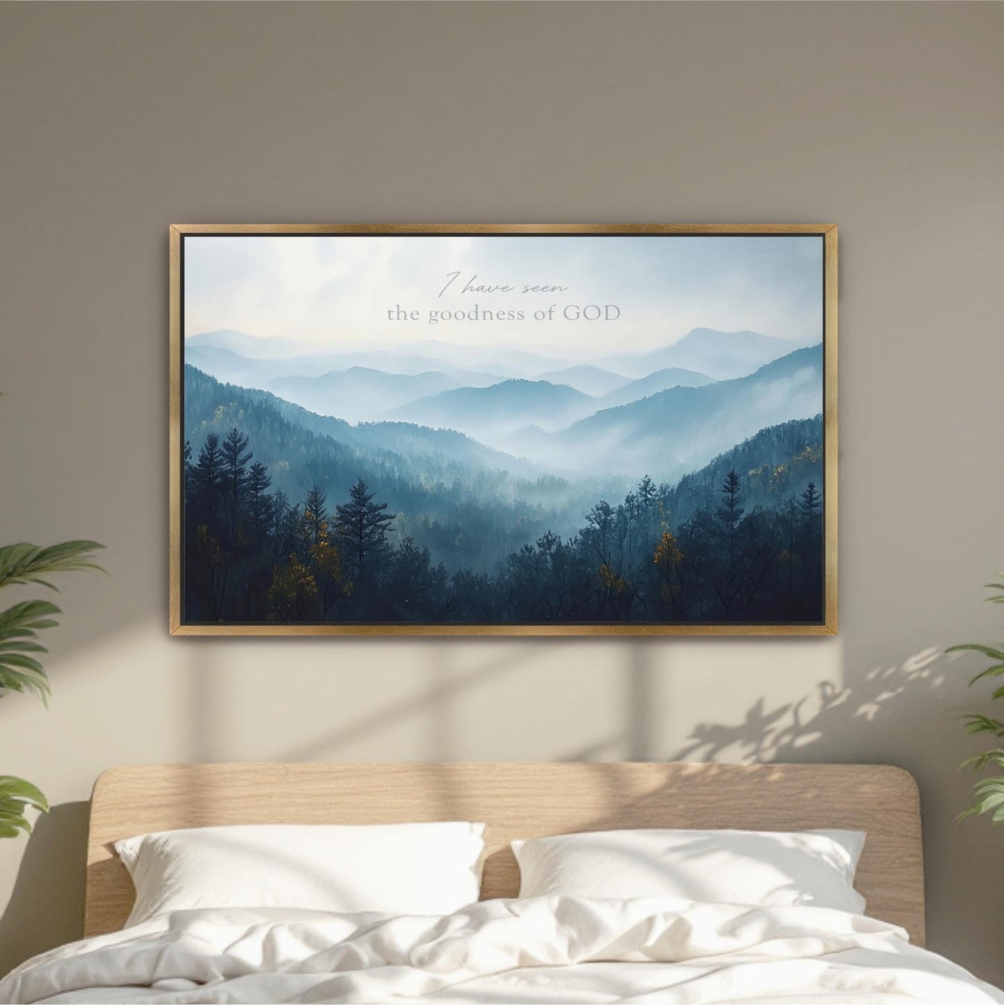 a framed landscape painting hanging on a wall above a bed with white pillows.