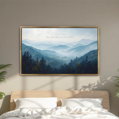 a framed landscape painting hanging on a wall above a bed with white pillows.