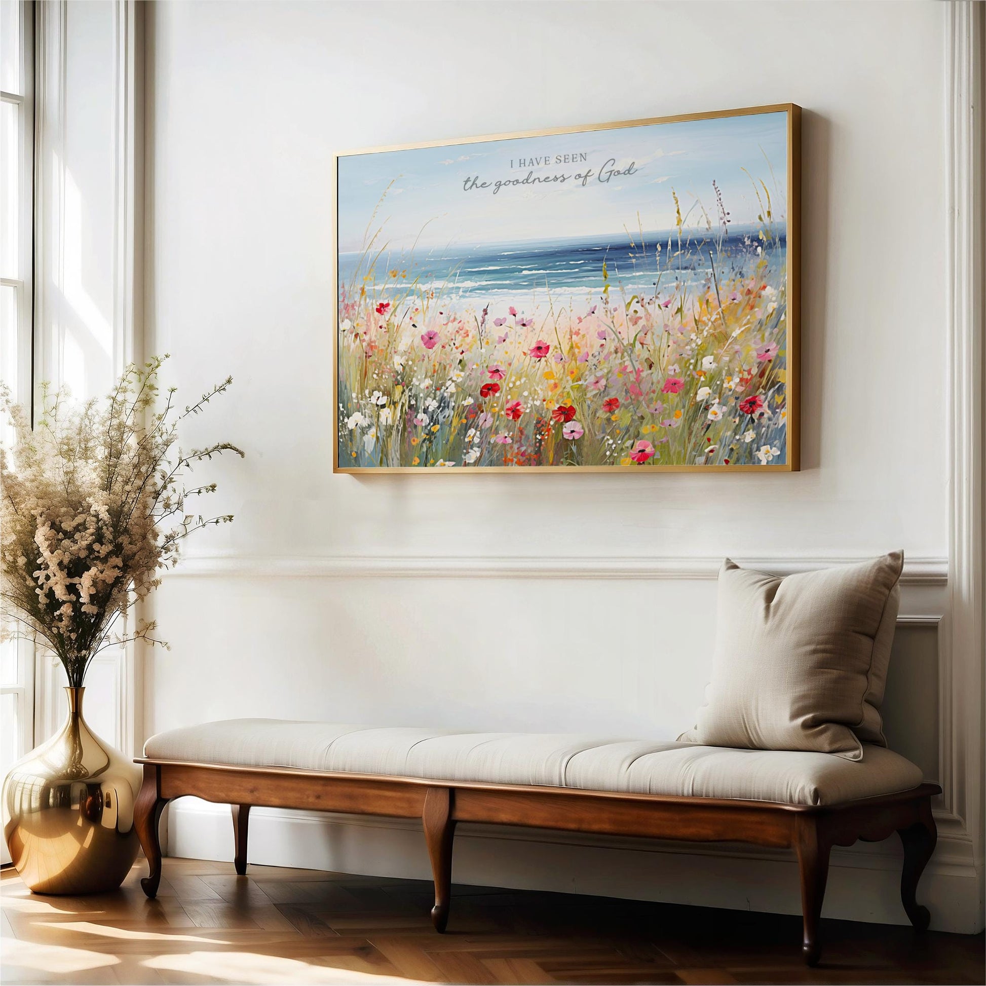 a large, framed painting of a field of flowers hanging on a white wall above a wooden bench.