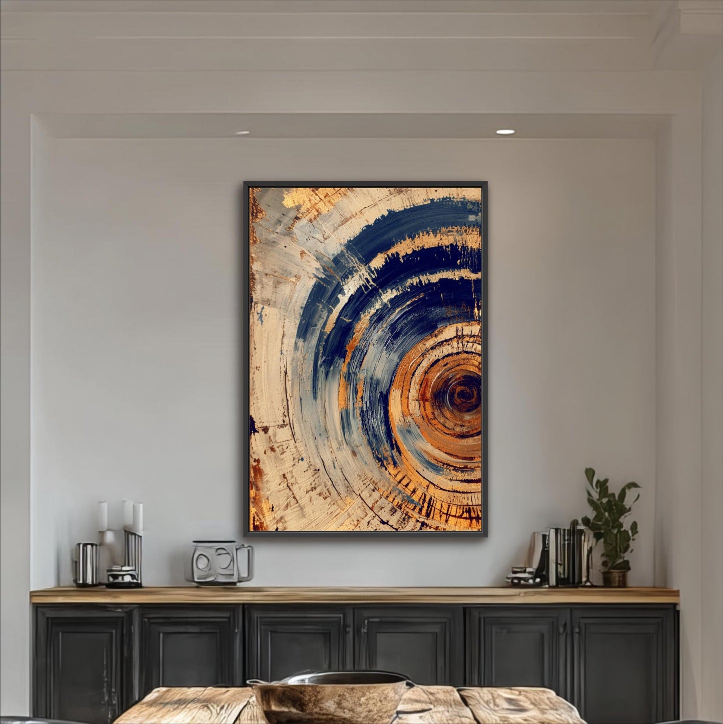 a large abstract painting hanging on a white wall above a wooden table with a black cabinet below it.