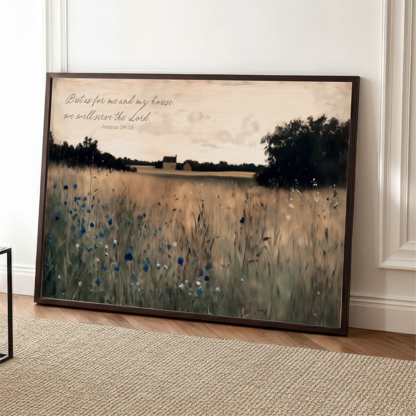 A framed painting depicting a serene landscape with a field of tall grass and trees in the background, accompanied by a Bible verse from Joshua 24:15.