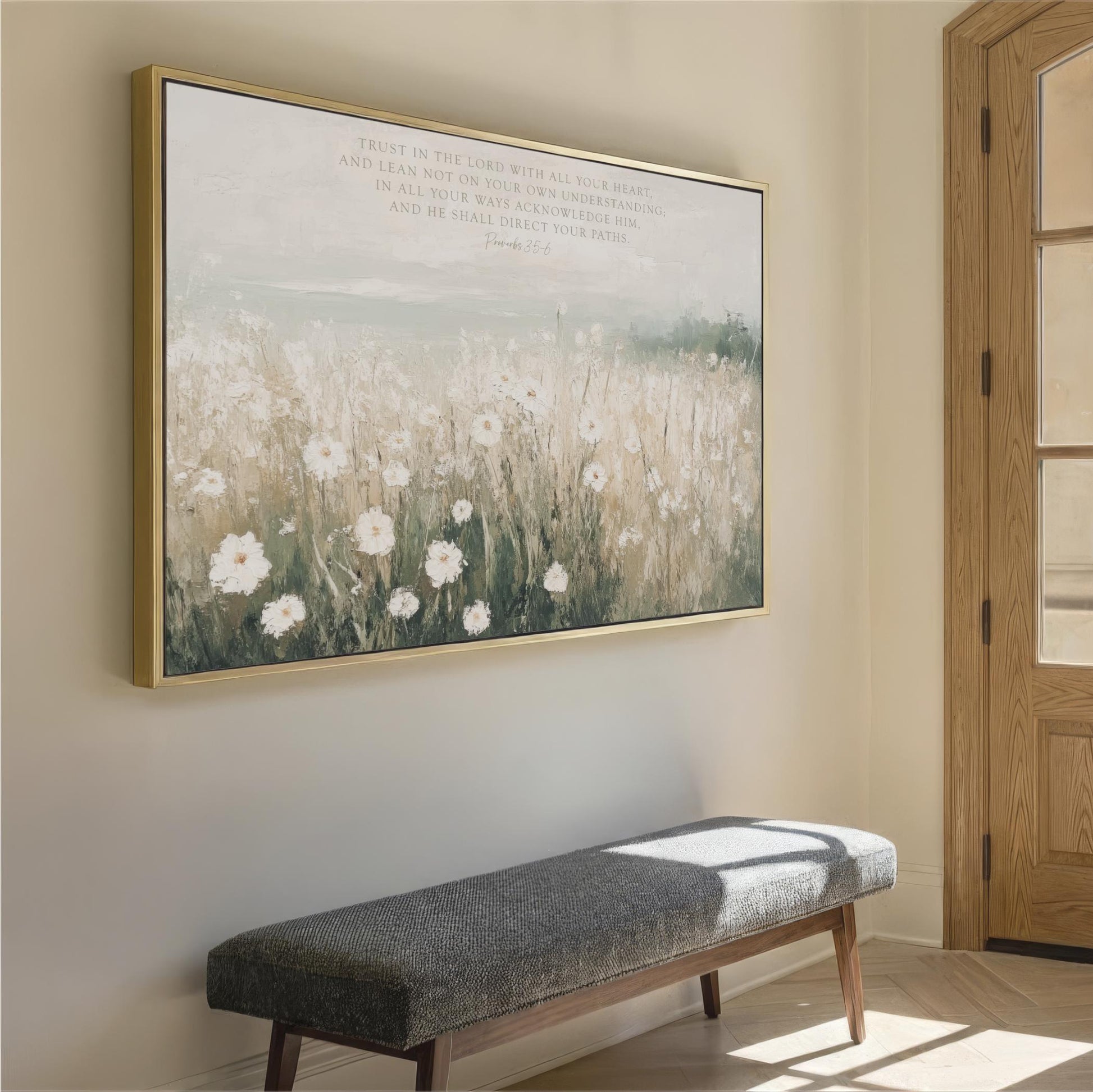 a large painting of a field with white flowers hanging on a wall, accompanied by a gray bench in the foreground.