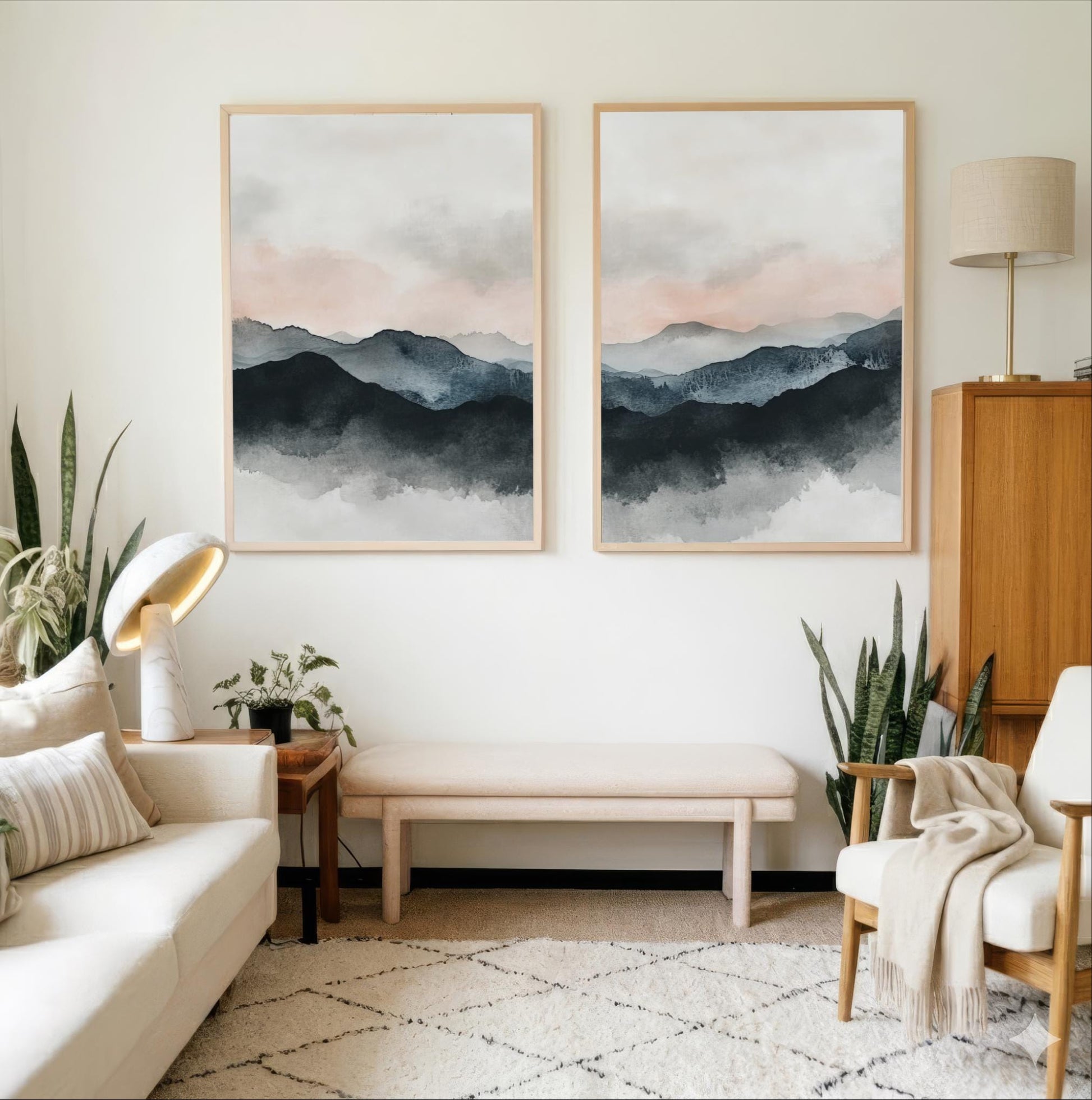 a cozy living room with a white sofa, a wooden side table, and two framed landscape paintings hanging on the wall.