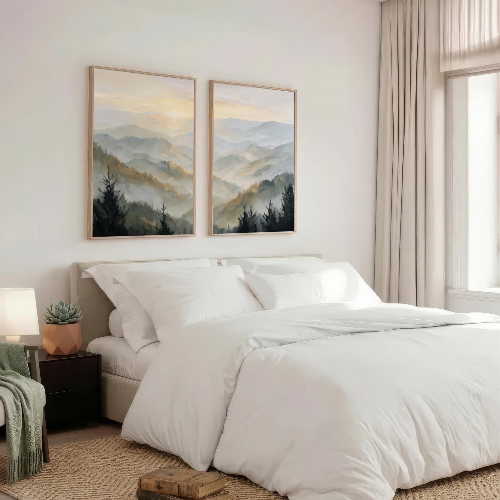 a serene bedroom with a large bed, white bedding, and two framed landscape paintings hanging above it. The paintings feature a mountain landscape with trees and a hazy, golden sky. The room has a neutral color scheme with beige walls and a wooden floor, creating a calm and peaceful atmosphere.