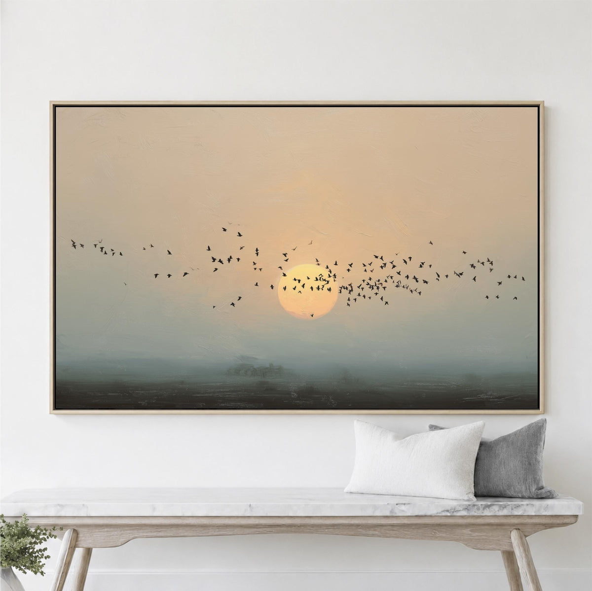 A large framed painting depicting a flock of birds flying over a landscape with a sunset in the background.