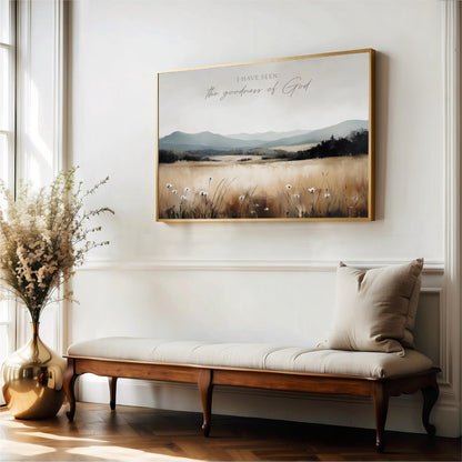 a large framed painting of a field with flowers hanging on a wall above a wooden bench with a beige cushion.