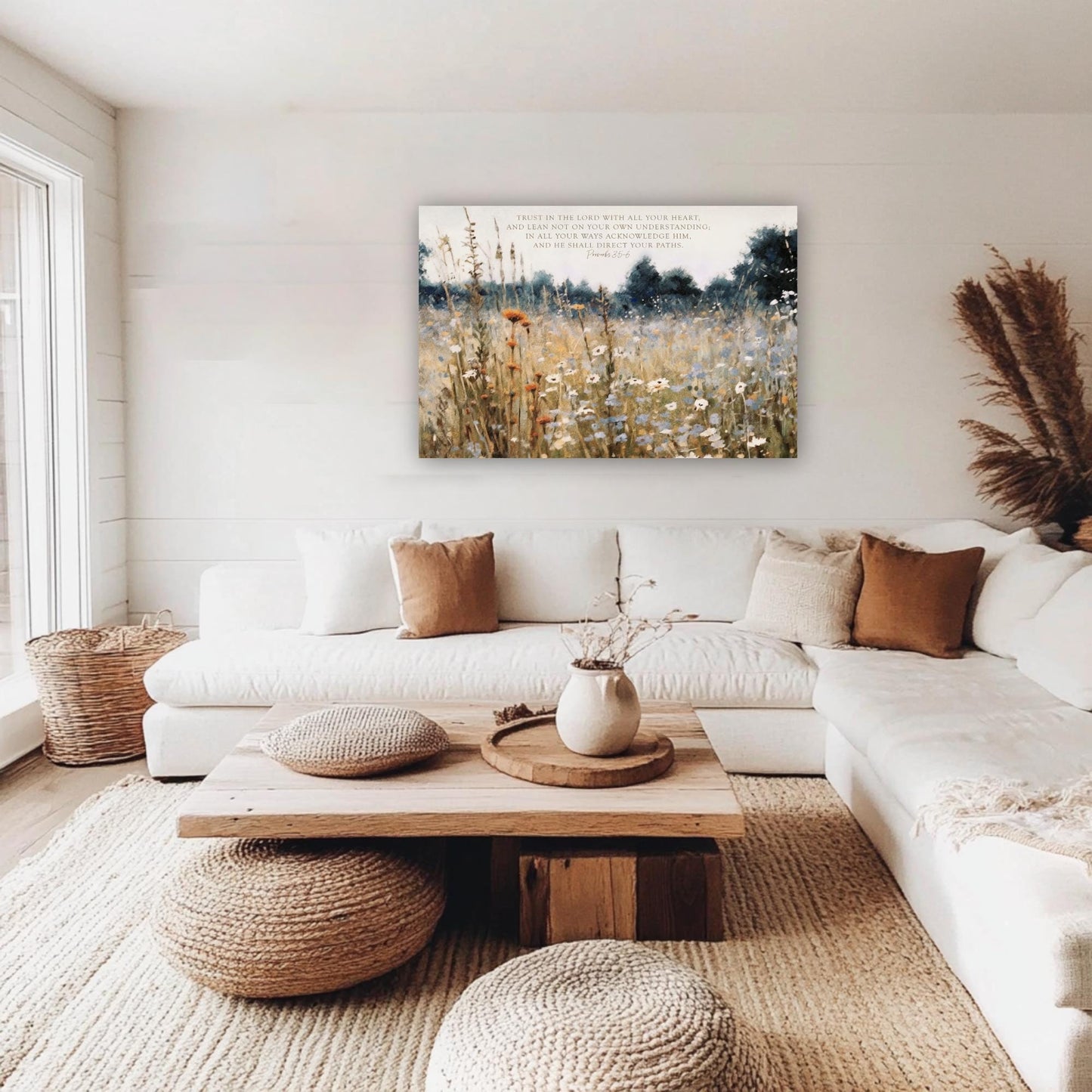 a cozy living room with a large white sectional sofa, a wooden coffee table, and a framed painting of a field of flowers hanging on the wall.