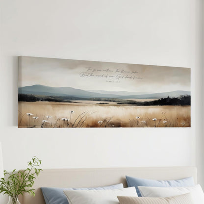 The image is a large canvas print depicting a serene landscape with a field of tall grass and mountains in the background. The text overlay on the canvas reads "The grass waters, but the world of God stands forever".
